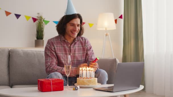 Fiesta en línea. Cumpleaños hombre volando galleta y beber champán, celebrando con amigos a través de videollamada en el ordenador portátil - Metraje, vídeo