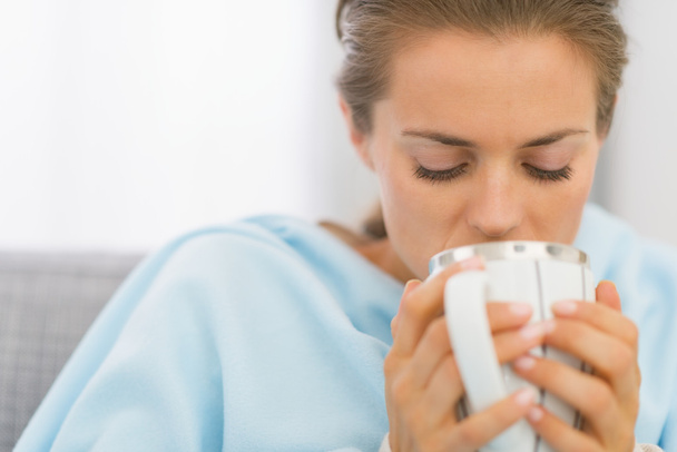 Ill young woman drinking hot beverage - Photo, image
