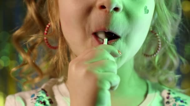 Primer plano de elegante adolescente caucásico niña labios lamiendo piruleta con lengua, cámara lenta - Metraje, vídeo