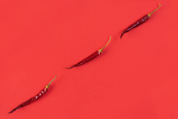 Dried red chili pepper on red background. Texture of isolated chili peppers - Photo, image