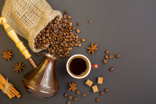 Top view of black coffee in the brown cup,coffee beans and turk for making coffee  on the dark background - Fotoğraf, Görsel