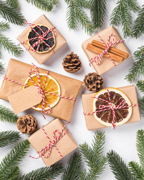 Χριστούγεννα διακοπές μηδέν απόβλητα χάρτινα δώρα περιτύλιγμα με ετικέτα, αποξηραμένα φρούτα και κλαδιά ελάτης - Φωτογραφία, εικόνα