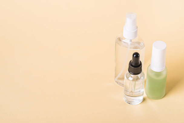 Esencia cuidado de la piel cosmética aceite orgánico en botellas sobre fondo beige - Foto, imagen