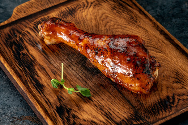 Drumstick chicken leg in barbecue sauce on a wooden chopping Board - Photo, Image