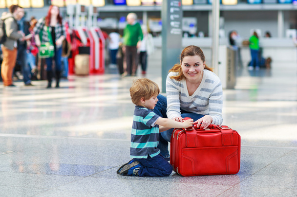 Mutter und kleiner Junge am Flughafen, drinnen - Foto, Bild