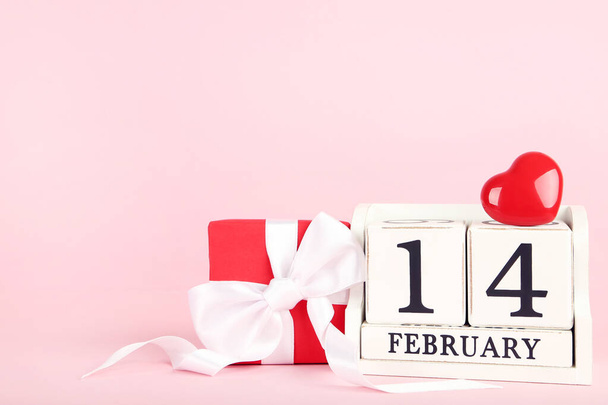 February block calendar with red heart and gift box on pink background - Foto, immagini