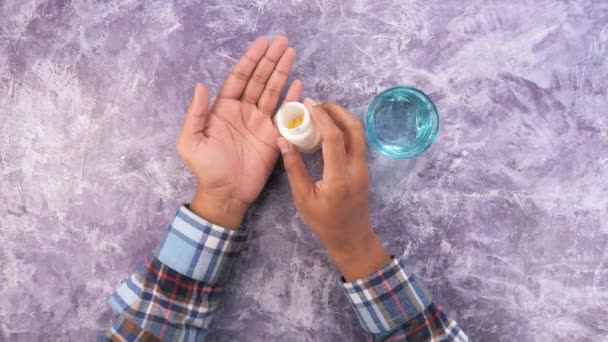 mans mano con la medicina derramada fuera del envase de la píldora  - Imágenes, Vídeo