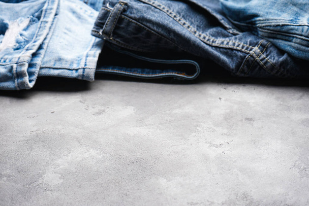 Modré džíny na šedém pozadí, místo pro text. Detailní záběr. - Fotografie, Obrázek