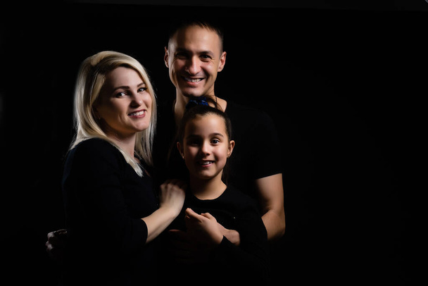 Familienporträt auf schwarzem Hintergrund - Foto, Bild