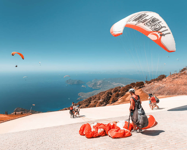 09 septembre 2020, Babadag, Oludeniz, Turquie : De nombreux aventuriers en parapente décollent en tandem avec un instructeur après une courte session d'entraînement pour le vol récréatif et la descente vers la mer - Photo, image