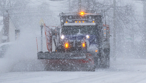 Un quitanieves trabajando en una tormenta con la nieve cayendo durante una ventisca en Long Island a principios de febrero de 2021. - Foto, Imagen