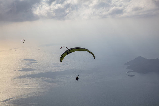 FethiyeOludeniz Babada je považován za jednu z nejdůležitějších paraglidingových oblastí na světě. Mula, Turecko. Skupina statečných paraglidistů vzlétla z hory Babadag u letoviska Oludeniz.  - Fotografie, Obrázek