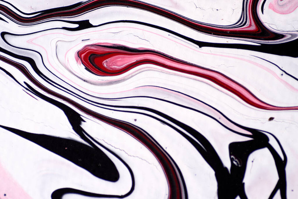 Macro shot of a mix of acrylic paint and oil on a marbled paper background. - Photo, Image
