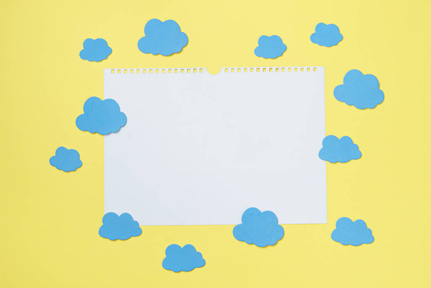 Composición creativa de la tarjeta de papel blanco rodeada de nubes maqueta, espacio de copia - Foto, Imagen
