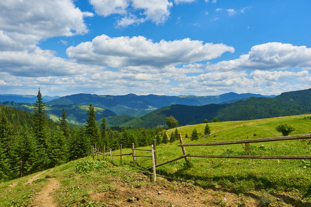 wooden fence on green meadow in mountains - Photo, Image