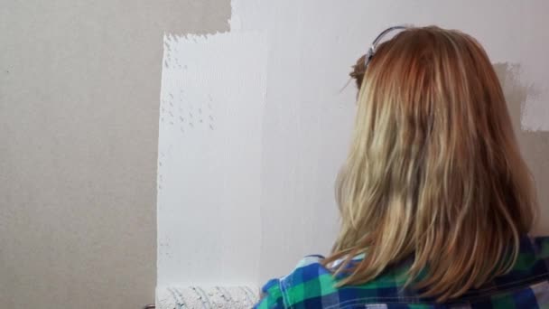 woman with painting roller and white paint coloring drywall - Footage, Video