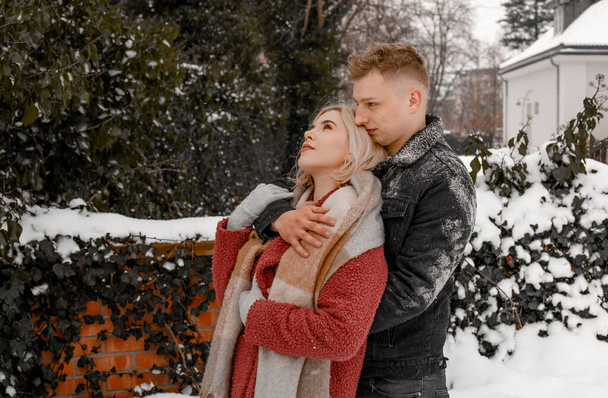 A loving couple in a gentle embrace. The guy kisses his girlfriend. Valentines day. Young guy hug his girlfriend in winter park. - Fotografie, Obrázek
