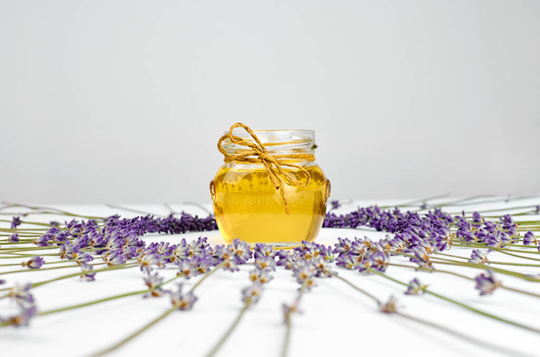 Jar with herbal honey and lavender flowers, sweet healthy food - Фото, изображение