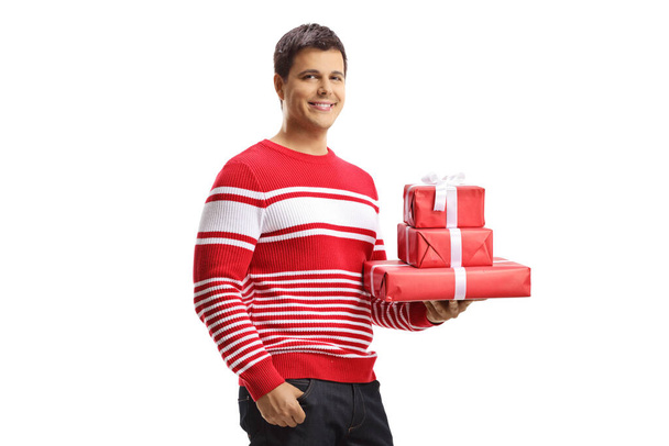 Junger Mann hält Geschenkboxen isoliert auf weißem Hintergrund - Foto, Bild