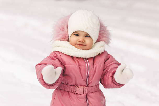 Милая маленькая девочка зимой на прогулке. Счастливые эмоции - Фото, изображение