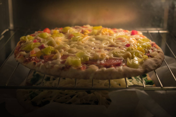 Заморожена піца з супермаркету або магазину спостерігається в гарячій електричній печі. Два супермаркету випічки один над іншим
. - Фото, зображення