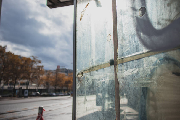 Schmutzige und fleckige Schaufenster eines Geschäfts oder einer Glasvitrine neben einer Hauptstraße in der Stadt. Schlechter Zustand einer Frontscheibe neben einer Straße. - Foto, Bild