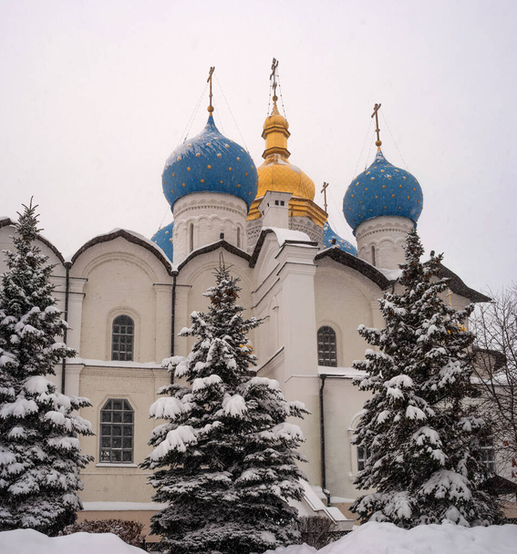 The Annunciation Cathedral of the Kazan Kremlin is an outstanding monument of Russian architecture of the XVI century. Winter, snowfall. Conifers in the snow - Φωτογραφία, εικόνα