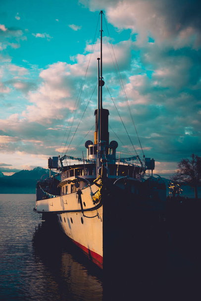 Vista frontal del viejo barco de vapor de principios del siglo 20 amarrado en el puerto de Ouchy en Lausana, Suiza en una mañana de invierno temprano soleado con algunas nubes sobre él. - Foto, Imagen