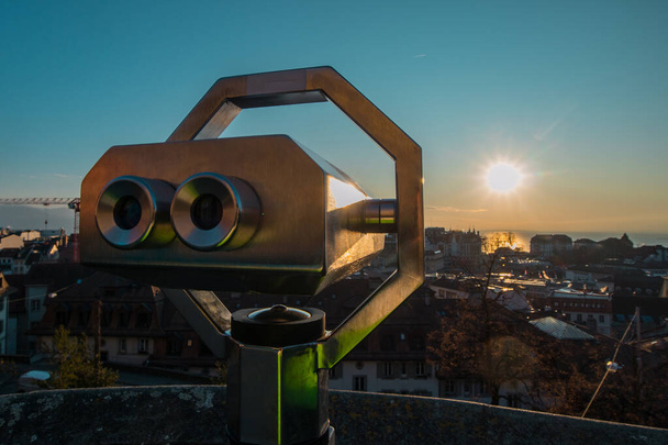 Binnoculars above the city of Lausanne to aid viewing the majestic cityscape at a romantic winter evening - Photo, Image