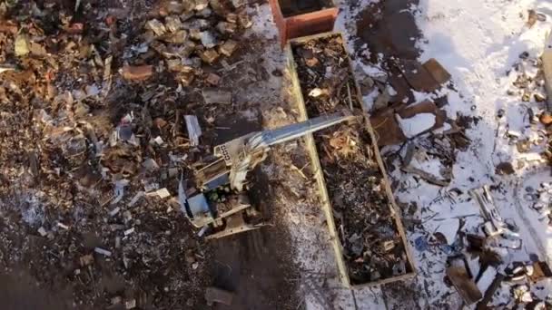 Luchtfotografie van schroot stortplaats, Crane unloads, ladingen schroot in een spoorwagon. - Video
