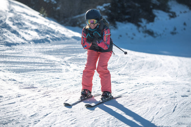 Νεαρή ξανθιά γυναίκα που κάνει σκι μια ηλιόλουστη μέρα. - Φωτογραφία, εικόνα