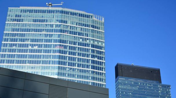 Facciata in vetro degli edifici con un cielo blu. Grattacieli nel centro della città d'affari.. Sfondo di edifici in vetro moderni.  - Foto, immagini