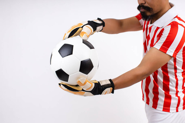 Fotbalový míč v ruce brankář izolované na bílém pozadí ve studiu. Trénink fotbalisty nebo fotbalový zápas. Asijský muž s kníry je brankář.  - Fotografie, Obrázek