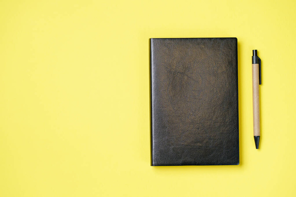 Leather notebook cover on a yellow background - 写真・画像