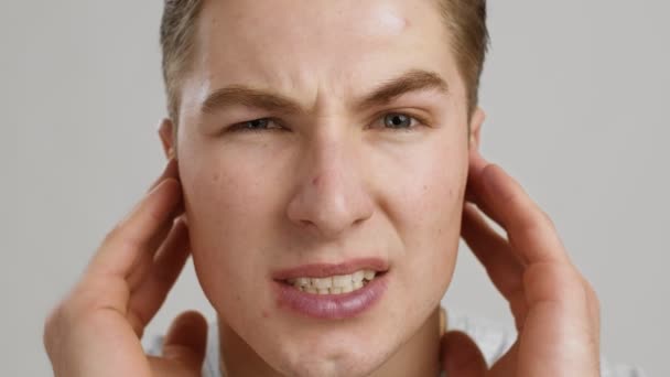 Een middenoorontsteking. close-up van jonge man die last heeft van oorpijn, schreeuwen van pijn, slow motion - Video