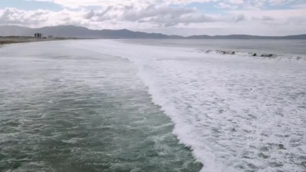 Schiuma di mare di surf rottura su una spiaggia con dune - Filmati, video