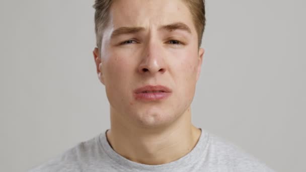 Allergie. Close-up van de jongeman niezen en blazen neus met papier weefsel, slow motion - Video