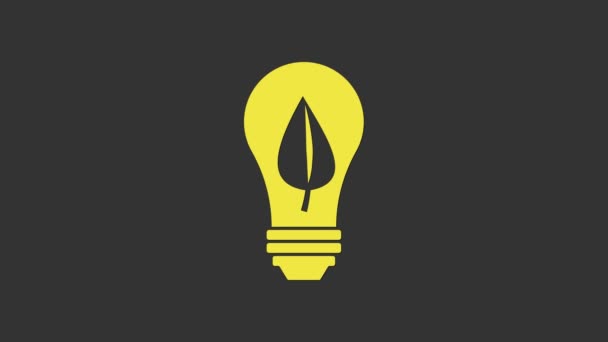 Bombilla amarilla con icono de hoja aislada sobre fondo gris. Concepto de energía ecológica. Concepto de energía alternativa. Animación gráfica de vídeo 4K - Metraje, vídeo