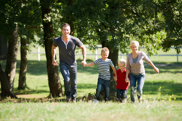 Family running in a park - Фото, изображение