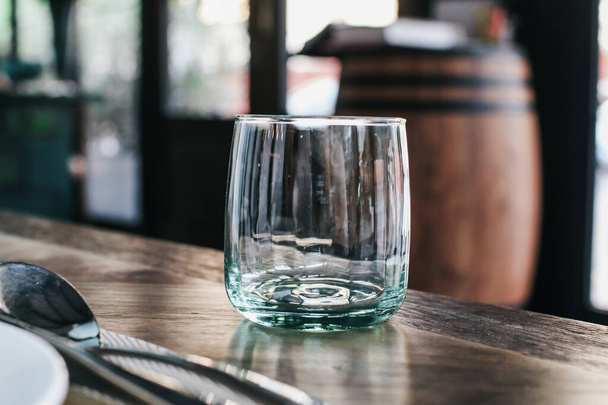 Leeg glas op de donkere houten tafel in restaurant. - Foto, afbeelding