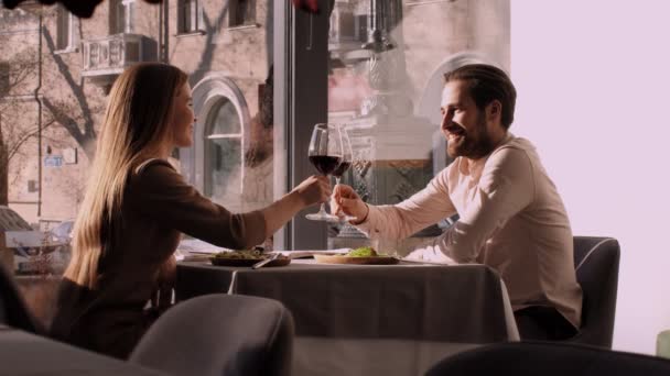 jong paar in liefde genieten van romantische date in cafe, klinken met wijnglazen - Video