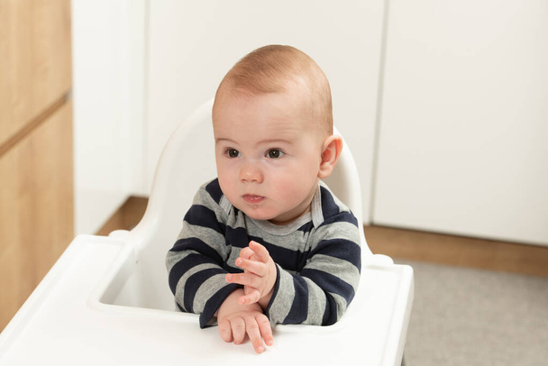 Little Baby Boy Sit on a Chair and Ready to Eat and Looking for Mom - Фото, изображение