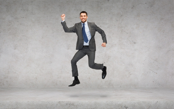 Smiling businessman jumping - Valokuva, kuva