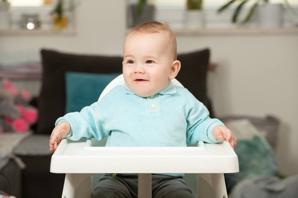 Portrait of a Joyful Baby Sitting on a High Chair - Фото, зображення