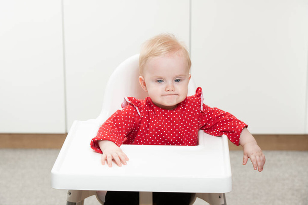 Little Baby Girl Sit on a Chair and Ready to Eat and Looking for Mom - 写真・画像