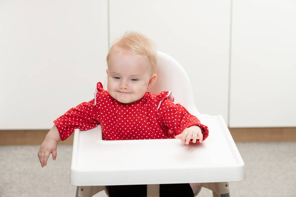 Happy Baby Sitting in High Chair in a White Kitchen - Foto, imagen