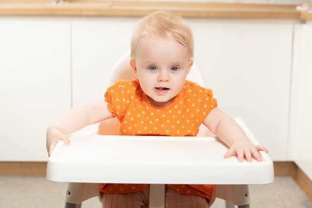 Happy Baby Sitting in High Chair in a White Kitchen - Fotoğraf, Görsel