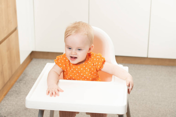 Happy Baby Sitting in High Chair in a White Kitchen - Foto, immagini