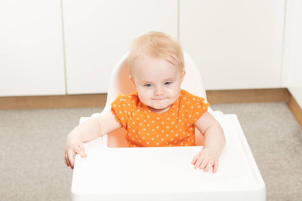 Portrait of a Joyful Baby Sitting on a High Chair - Foto, Imagem