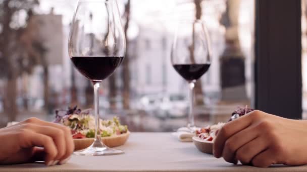 Крупним планом знімок романтичної пари тримає руки в кафе, зустрічається з келихами для вина, повільний рух
 - Кадри, відео